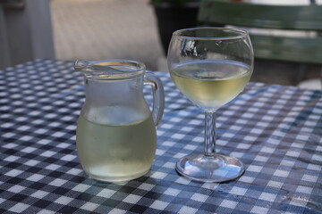 Wei&szlig;wein serviert in Karaffe und Glas in einer griechischen Taverne