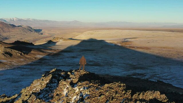A man stands on the edge of a cliff and looks into the distance. Altai mountains, Siberia