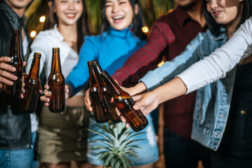 Portrait of Happy Asian friends having dinner party together - Young people toasting beer glasses dinner outdoor  - People, food, drink lifestyle, new year celebration concept.