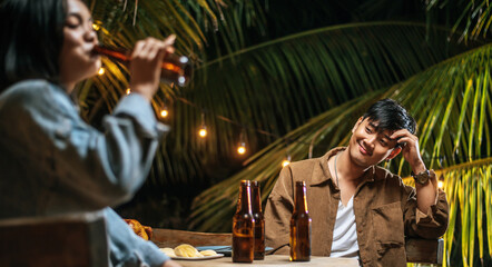 Portrait of Happy Asian friends having dinner party together - Young people toasting beer glasses dinner outdoor  - People, food, drink lifestyle, new year celebration concept.