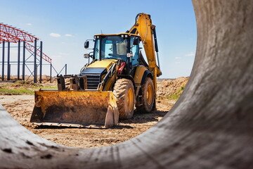 The excavator backfills the pit with the front bucket. Moves soil around the construction site....