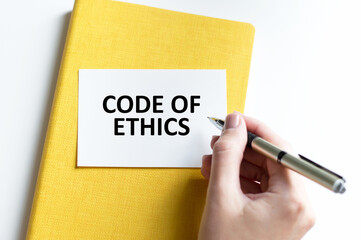 Businessman putting a card with text code of ethics