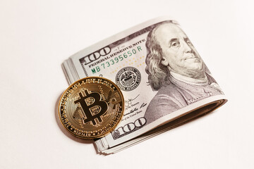 golden bitcoin coin with 100 dollar bills