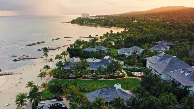 Cinematic Drone Shot of Tropical Beach in Montego Bay - Jamaica.
Stunning Aerial view of Sunrise at the Caribbeans. Golden light illuminating the beach.