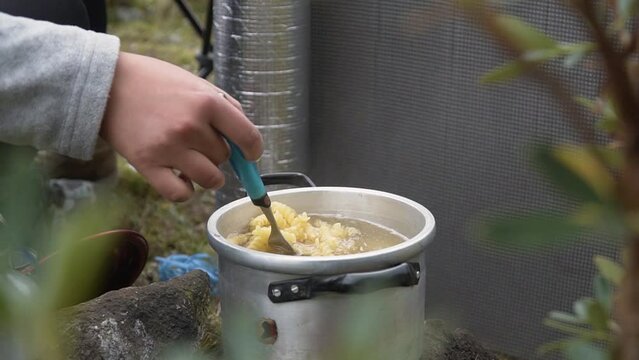Woman Stirring And Cooking Rotini Pasta On A Casserole. - close up