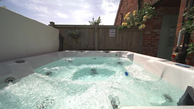 Slow wide side to side shot of private hot tub jacuzzi at vacation rental in summer,