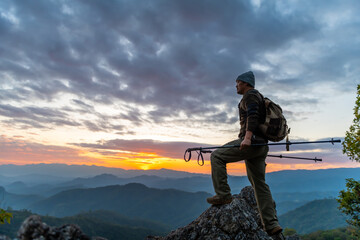 Happy tourists on top of mountain at sunset outdoors during summer hiking