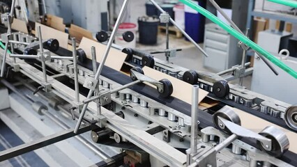 line for the production of brown cardboard boxes. Conveyor line for the production of corrugated cardboard boxes. Modern factory of production cardboard box from recycled paper. Slow motion video.