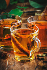 Hot Mulled Cider glass cups: apple, pear and orange drinks with spices. Fermented low alcohol winter cocktail on rustic wooden table