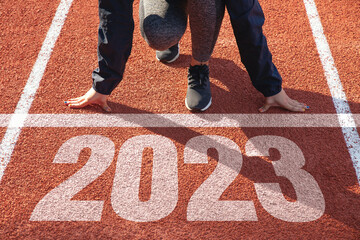 Happy new year 2023 symbolizes the start of the new year. Women preparing to run on the athletics...
