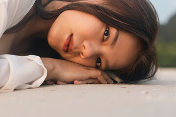 Obraz premium Close up of the beautiful asian women lying on the beach in the summer. Asian woman vacationing at the beach in the evening.