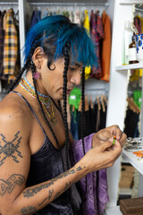 indigenous non-binary artist with blue hair getting dressed