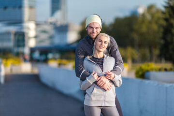 Two Embracing Positive Caucasian Runners Athletes Relaxing During Training Together And Smiling As Fitness Exercise Outside While Training Outdoor Process.