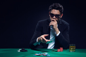 Gambling Concepts. One Emotional Handsome Caucasian Brunet Cards Player At Pocker Table With Chips Flying and Cards While Playing and Drinking