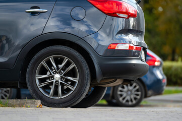 Closeup of back or rear side of cars parking in line parking area near street in twilight evening