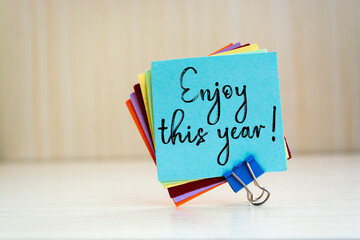 The words Enjoy this year write on Sticky Notes.