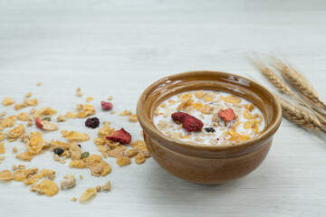 A bowl of cereal with dried fruits and milk placed on a wooden table, perfect for illustrating healthy breakfast, nutrition, and food photography.
