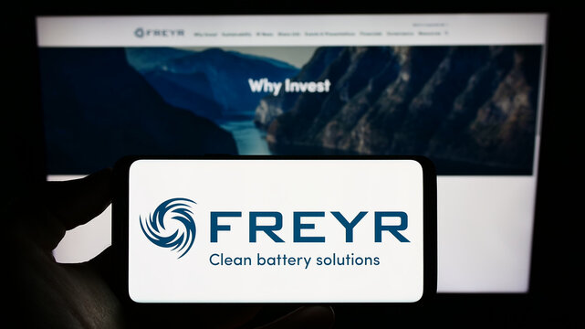 Stuttgart, Germany - 12-10-2022: Person holding cellphone with logo of Norwegian battery company Freyr AS on screen in front of business webpage. Focus on phone display.