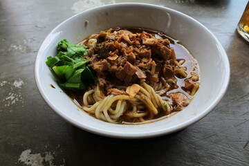 Indonesian authentic and traditional meatballs soup - Bakso soup on white cup and marble background