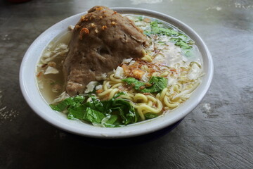 Indonesian authentic and traditional meatballs soup - Bakso soup on white cup and marble background