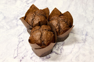 homemade chocolate muffins on white marble