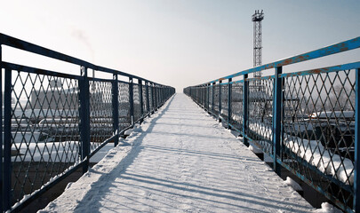 Old pedestrian bridge over the railway. Trains and carriages. Winter, snow. Ust-Kamenogorsk...