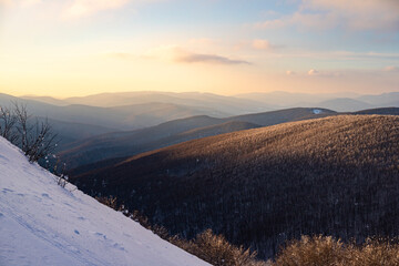 panorama of snow-capped mountains at sunset during a cold winter  mighty mountain peaks in the Polish Bieszczady mountains  mountain vegetation covered with snow © Lens Down Under