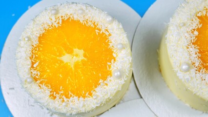 Small cakes with orange and coconut on a blue background.