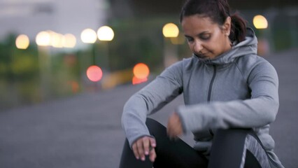 Night, woman or tired runner after fitness training, running exercise or workout resting on city street or road. Fatigue, mindset or exhausted sports athlete girl in hoodie relaxing or breathing