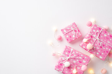 Saint Valentine's Day concept. Top view photo of stylish gift boxes in wrapping paper with heart pattern light bulb garland and fluffy pompons on isolated white background with copyspace