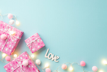Valentine's Day concept. Top view photo of present boxes in wrapping paper with heart pattern light bulb garland inscription love and soft pompons on isolated pastel blue background with blank space