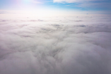 Aerial top view cloudscape. Texture of clouds. View from above. Sunrise or sunset over clouds in sunny weather