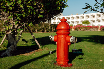 Fototapeta na wymiar red fire hydrant on a manicured and green lawn
