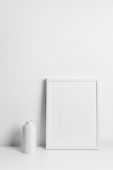 Blank white portrait frame mockup in minimalistic interior with copy space for artwork, photo or print presentation