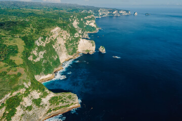 Aerial view of coastline with cliffs and blue ocean in Nusa Penida island, Indonesia.