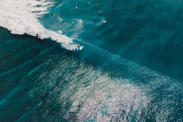 Aerial view with surfing on wave. Perfect waves with surfers in blue ocean