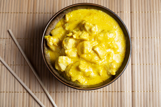 Spicy chicken in curry sauce on a bamboo napkin with chopsticks. Dish of Asian cuisine