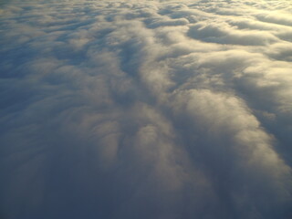 flight above clouds through the cloudy sky