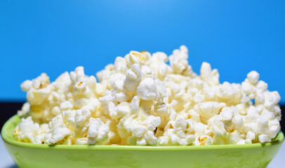Close up. Popcorn in a green bowl, ready to eat while watching a movie.