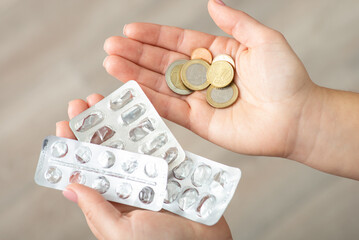 Empty blister packs of pills and euro coins in female hands. Medicine, high costs of expensive...