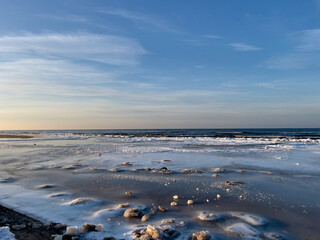 Winter landscape with sea covered with ice and blue clear sky above, selective focus