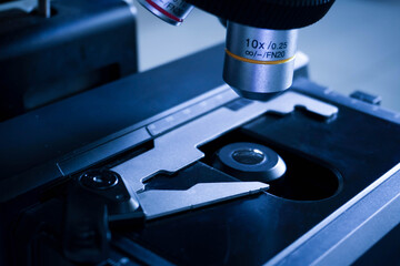 Close-up shot of microscope with metal lens at laboratory. research chemistry equipment scope biotechnology