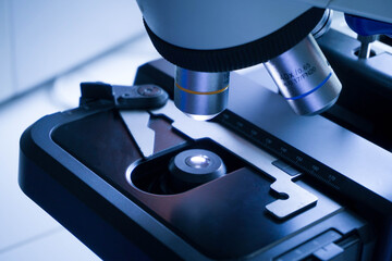 Close-up shot of microscope with metal lens at laboratory. research chemistry equipment scope biotechnology