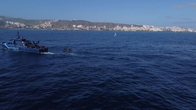 Aerial shot of a police patrol next to one of the boats it owns. Customs patrol against drug trafficking.