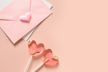 Valentine's day card with envelope and pink lollipops as heart on pink background. View from above. Copy space.