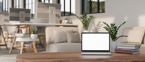 Laptop mockup and decor on coffee table over blurred background of modern office workplace