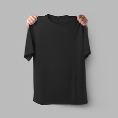 Oversized black t-shirt template, hands holding shoulders, isolated on background, front view.