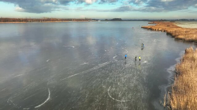 Ice skating on the Drontermeer lake in nature seen from above during a cold winter day in The Netherlands.