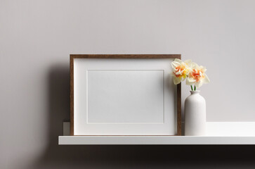 Blank landscape picture frame mockup on shelf with flowers, mockup with copy space