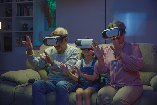 Asian granddaughter and grandparents playing together exciting interesting video games using virtual reality headsets living room at home, elderly with child play VR video game, family entertainment - Powered by Adobe
